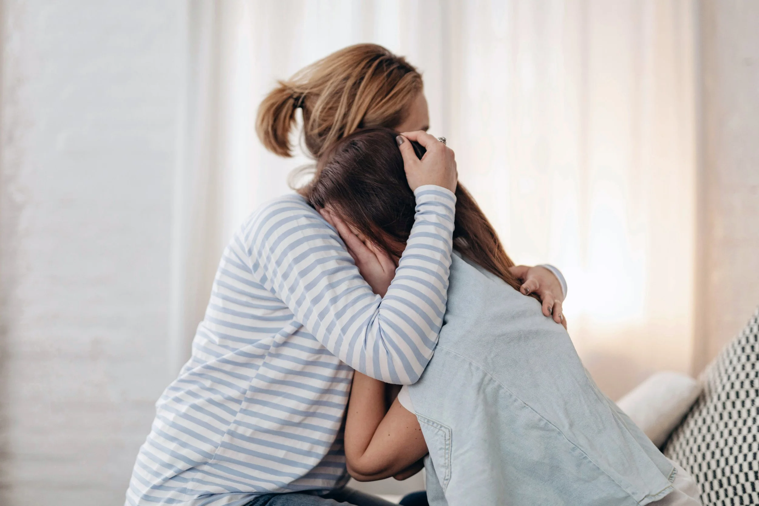 Two pairs of hands clasped together